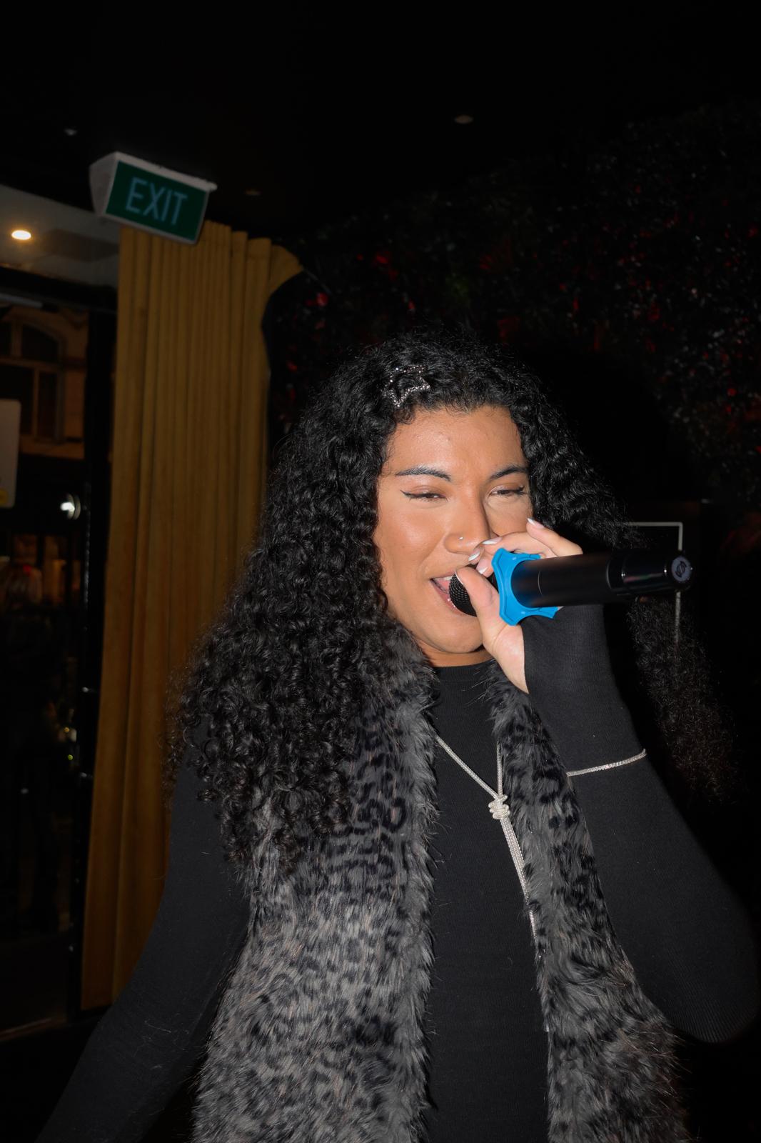 A singer performing karaoke at Illumina